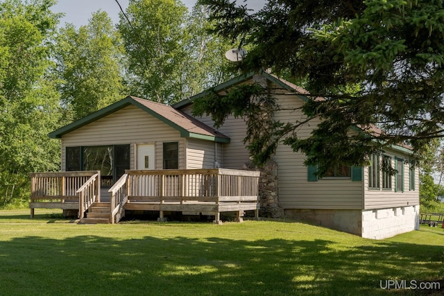 rear view of house with a wooden deck and a yard