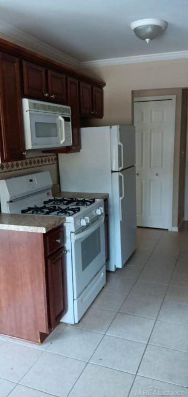 kitchen featuring light tile patterned floors, white appliances, and ornamental molding