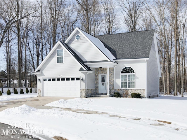 traditional home featuring stone siding, an attached garage, a shingled roof, and driveway