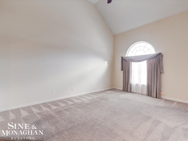 spare room with ceiling fan, light colored carpet, and lofted ceiling