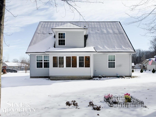 view of snow covered back of property