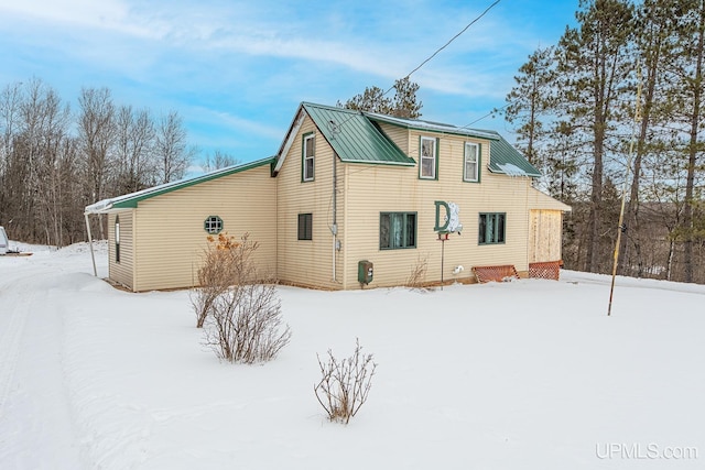 view of snow covered rear of property