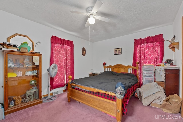 carpeted bedroom featuring ceiling fan and a textured ceiling