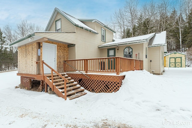 snow covered house with a storage unit