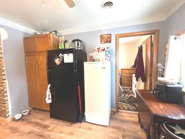 kitchen with ceiling fan, fridge, black refrigerator, and light wood-type flooring