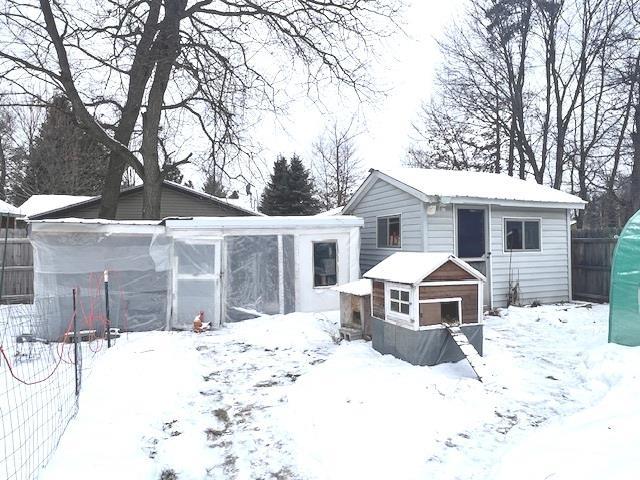 snow covered property featuring an outbuilding