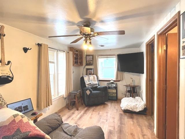 living room featuring hardwood / wood-style floors and ceiling fan