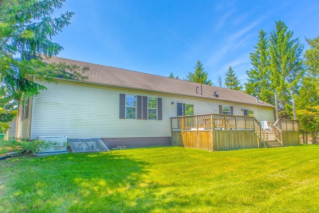 rear view of house featuring a lawn and a deck