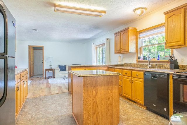 kitchen with a kitchen island, sink, a textured ceiling, and black appliances