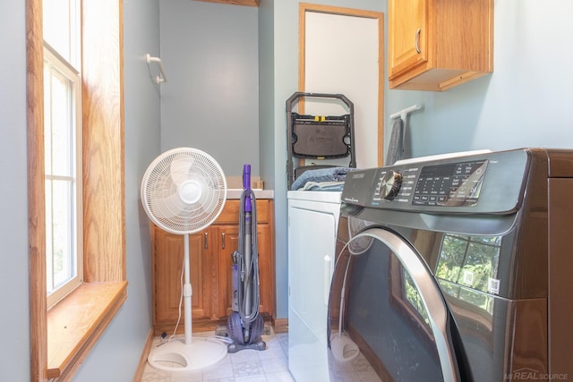 laundry room with separate washer and dryer and cabinets