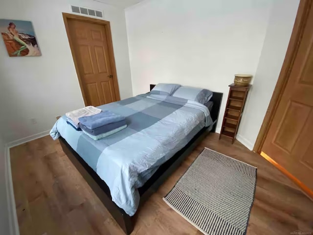 bedroom with dark hardwood / wood-style floors