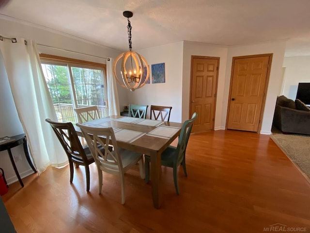 dining area with hardwood / wood-style floors and an inviting chandelier