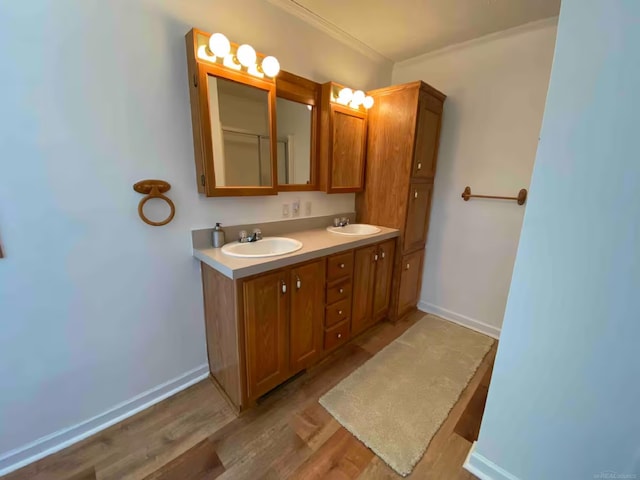 bathroom featuring hardwood / wood-style flooring, ornamental molding, and vanity