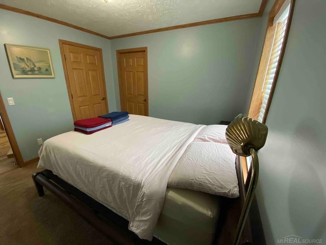 carpeted bedroom with ornamental molding and a textured ceiling