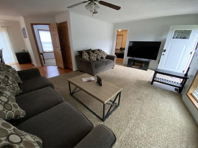 carpeted living room with ceiling fan