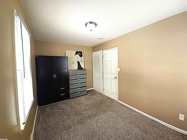 unfurnished bedroom with dark carpet