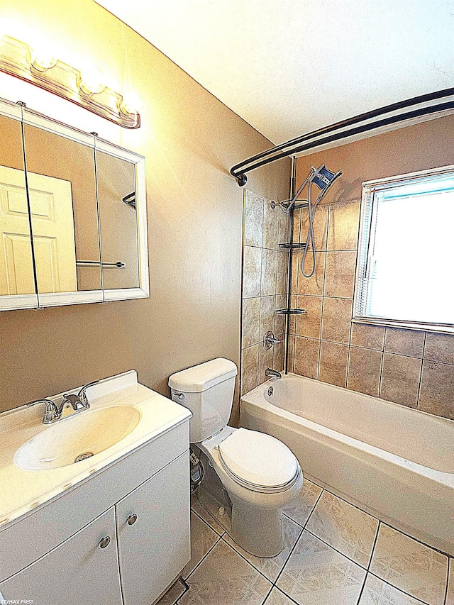 full bathroom with tile patterned flooring, vanity, tiled shower / bath combo, and toilet