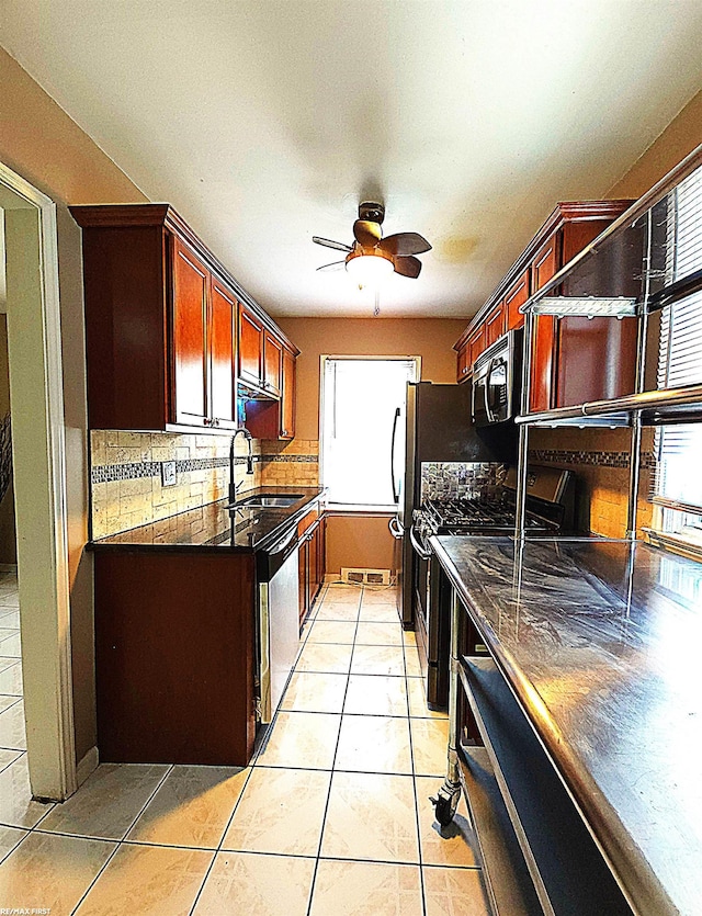 kitchen with dishwasher, sink, decorative backsplash, stove, and light tile patterned floors