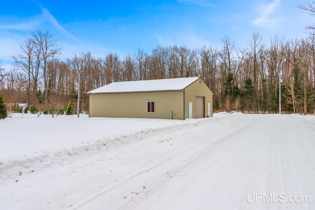 snow covered structure with a garage