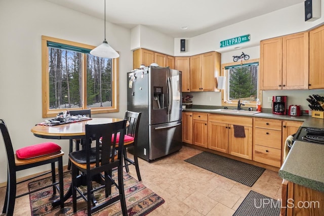 kitchen with sink, decorative light fixtures, a wealth of natural light, and appliances with stainless steel finishes