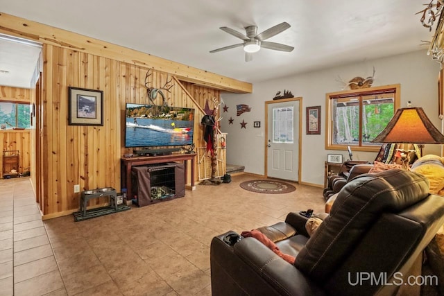 living room with beam ceiling, ceiling fan, and wooden walls