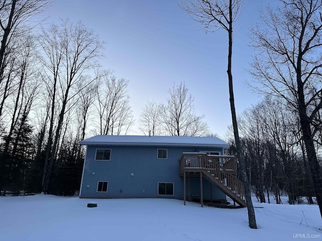 snow covered property with a wooden deck