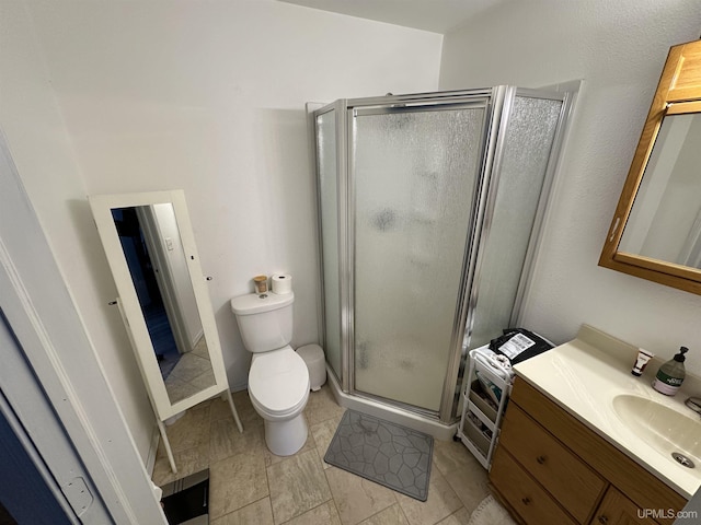 bathroom featuring vanity, walk in shower, and toilet