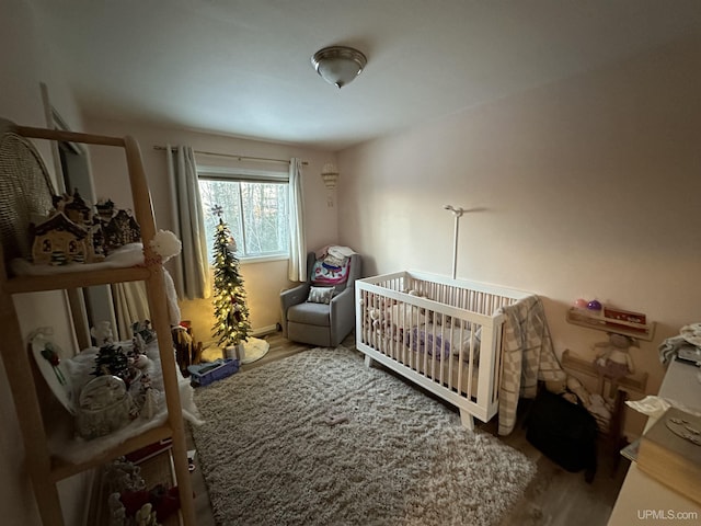 bedroom featuring a crib and wood-type flooring