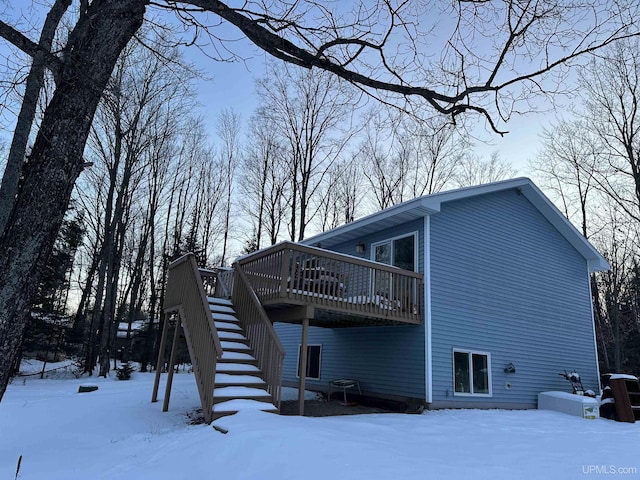 view of snowy exterior featuring a deck