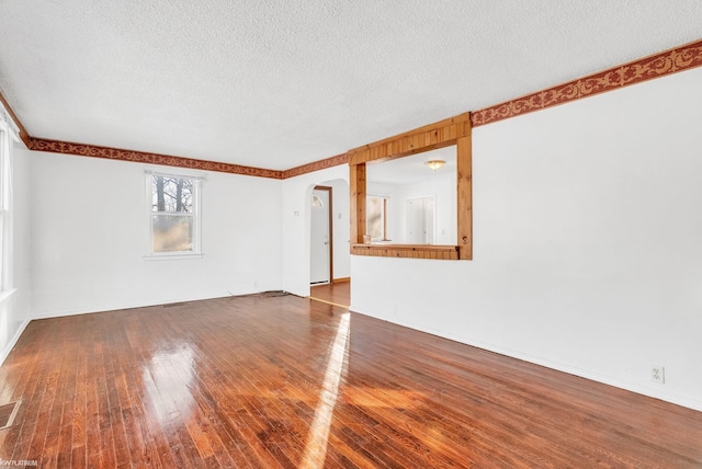 empty room featuring wood-type flooring and a textured ceiling