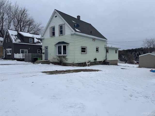 view of snow covered rear of property