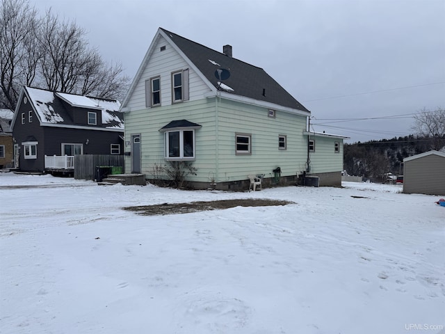 view of snow covered rear of property