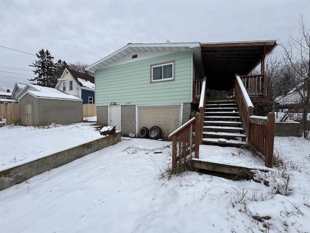 snow covered property with a garage