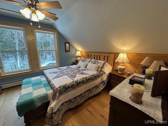 bedroom with hardwood / wood-style floors, vaulted ceiling, and ceiling fan