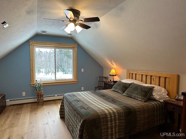 bedroom featuring light hardwood / wood-style flooring, ceiling fan, vaulted ceiling, a textured ceiling, and a baseboard radiator