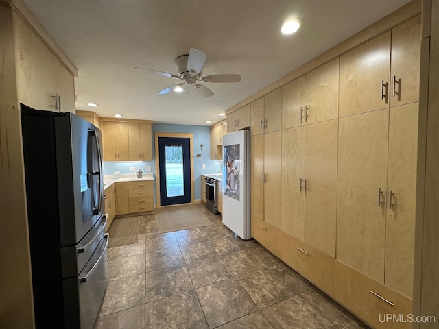 kitchen featuring stainless steel appliances, ceiling fan, and light brown cabinetry