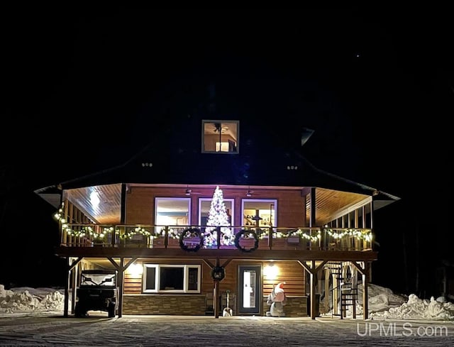 back house at night featuring a wooden deck