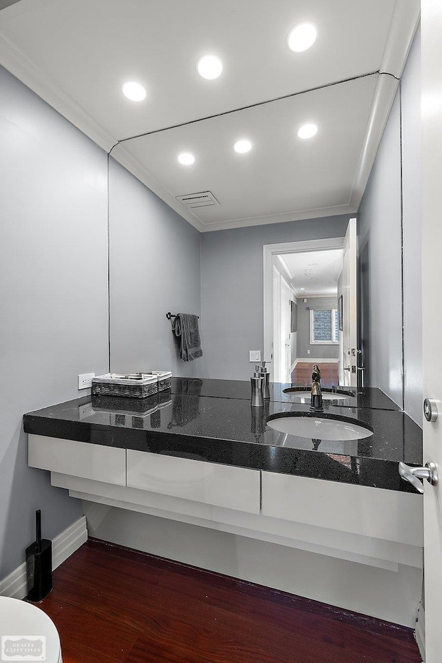 bathroom with crown molding, vanity, and hardwood / wood-style flooring