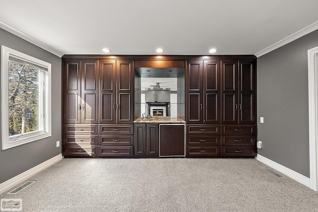 interior space featuring ornamental molding and light carpet