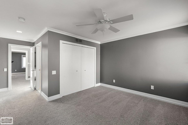 unfurnished bedroom featuring crown molding, ceiling fan, carpet floors, and a closet