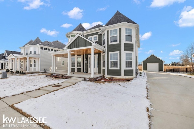 view of front facade featuring a garage, an outdoor structure, and a porch