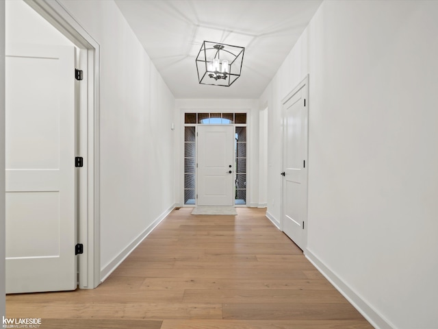 hall featuring a chandelier and light wood-type flooring