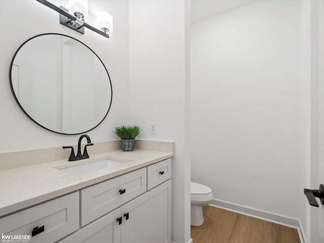 bathroom with vanity, hardwood / wood-style flooring, and toilet