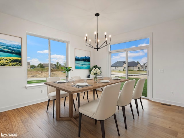 dining space featuring an inviting chandelier and light hardwood / wood-style flooring