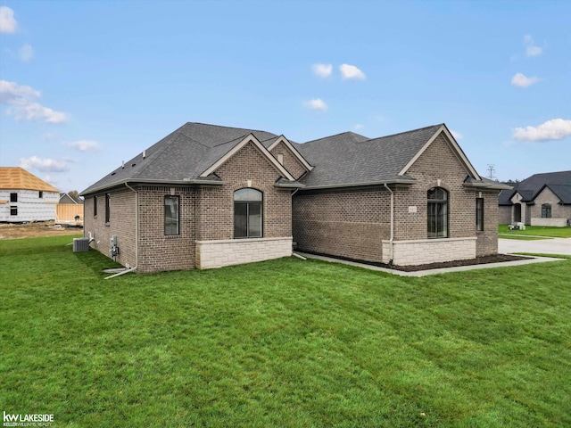 view of front of home featuring cooling unit and a front lawn