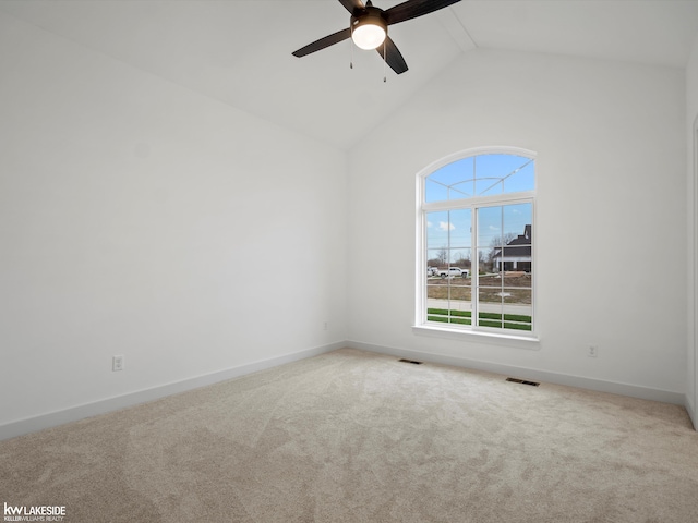 empty room with ceiling fan, high vaulted ceiling, and carpet floors