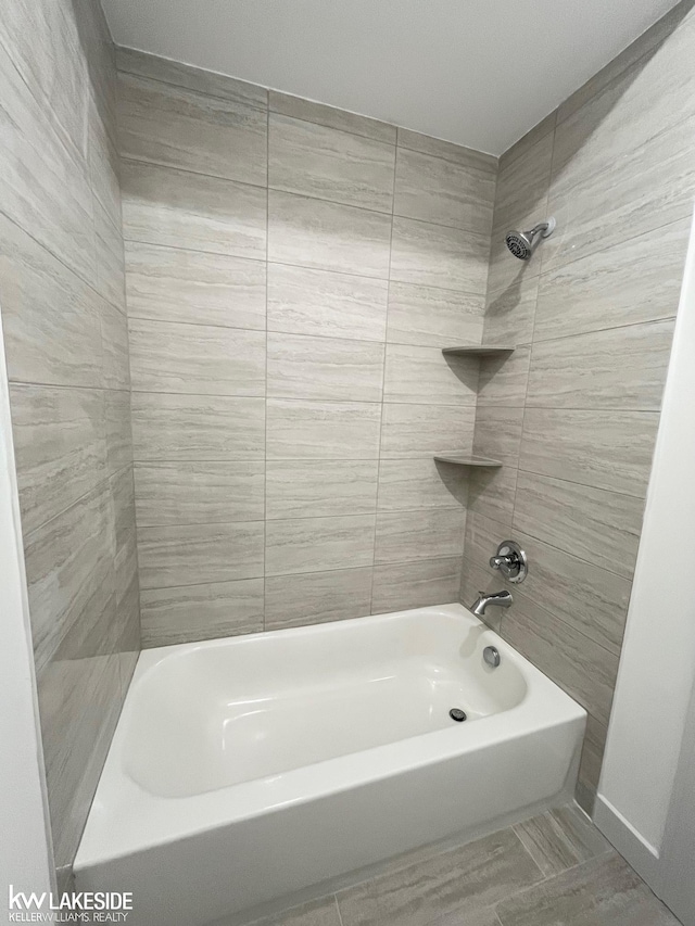 bathroom featuring tiled shower / bath