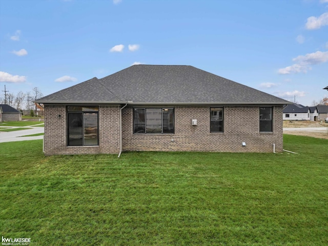 rear view of property featuring a lawn