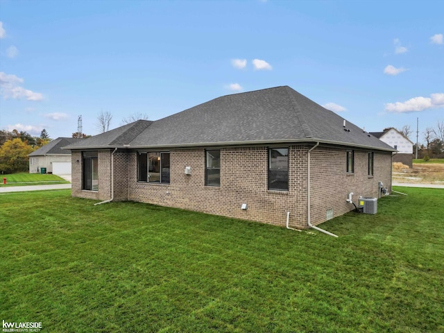 view of side of home featuring cooling unit, a yard, and a garage