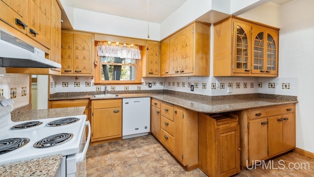 kitchen with light stone counters, white appliances, kitchen peninsula, and sink